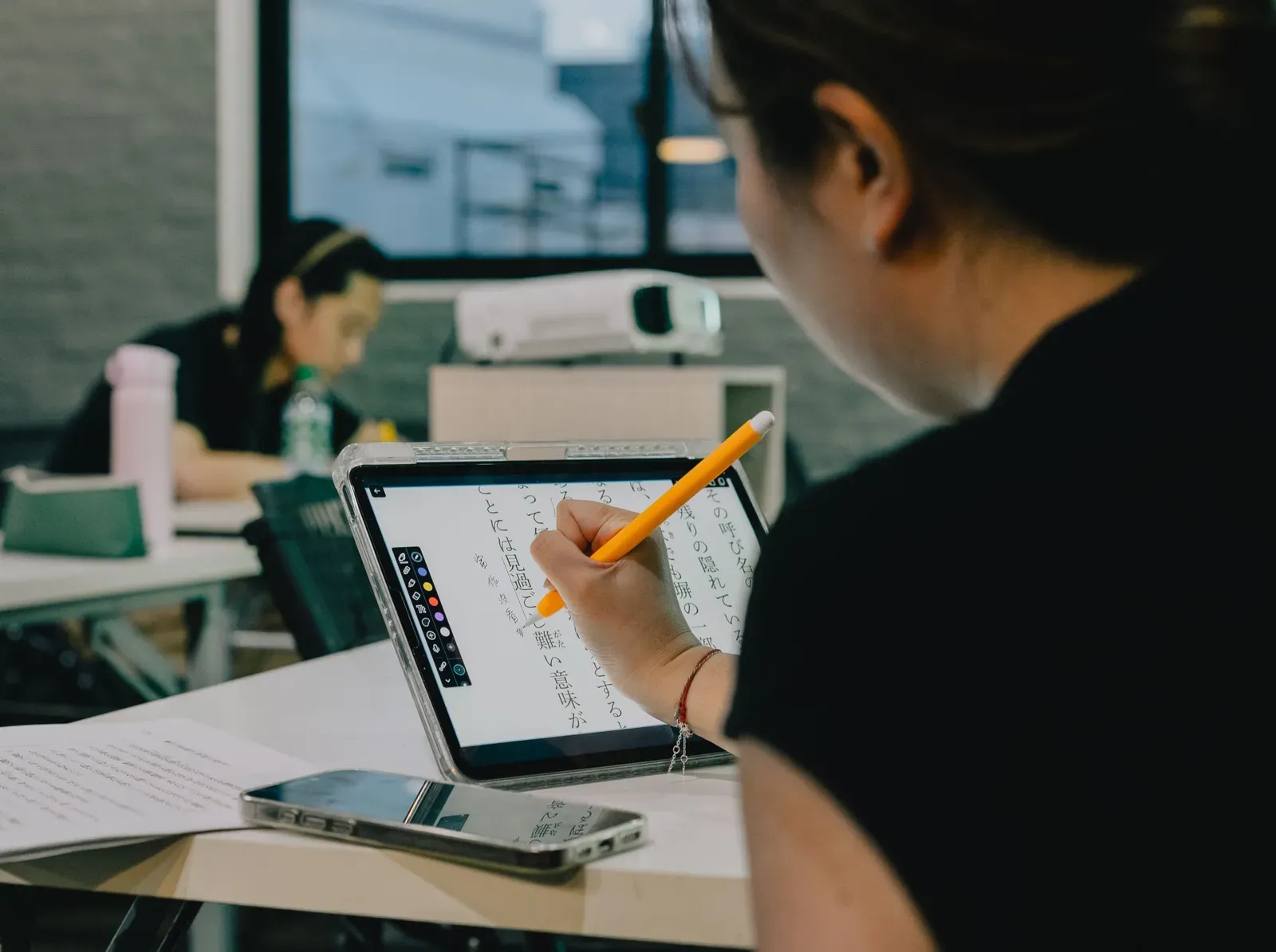 Schülerin schreibt mit einem Stift auf einem Tablet